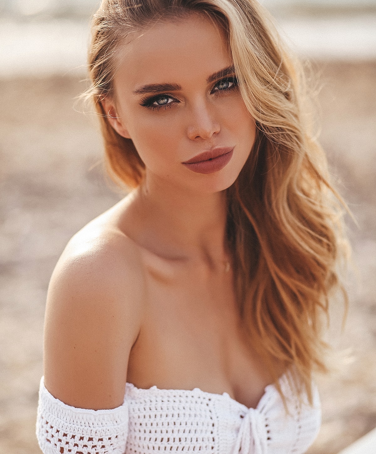 Woman with blonde hair in a white top.