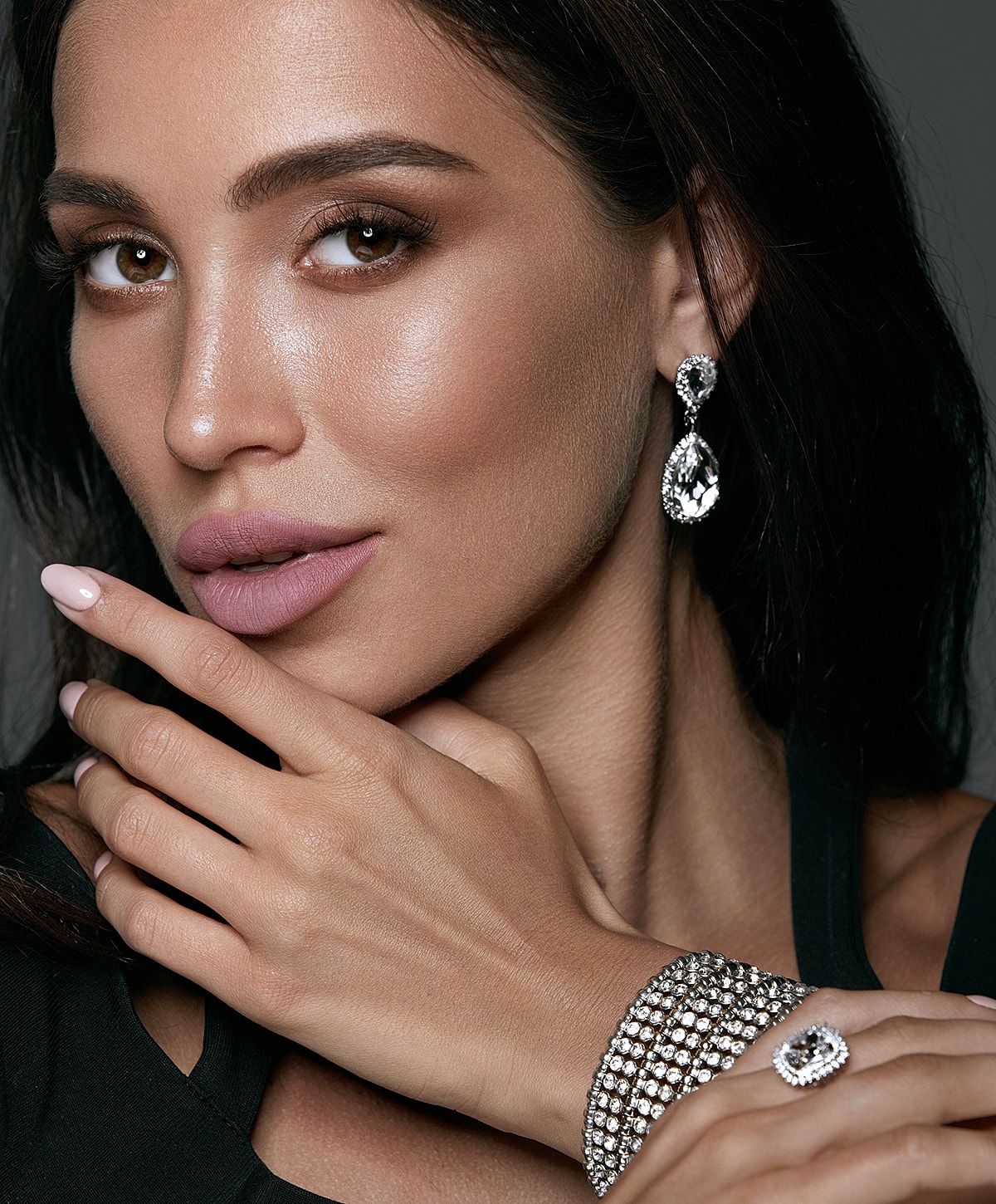 Woman with jewelry, elegant pose and makeup.