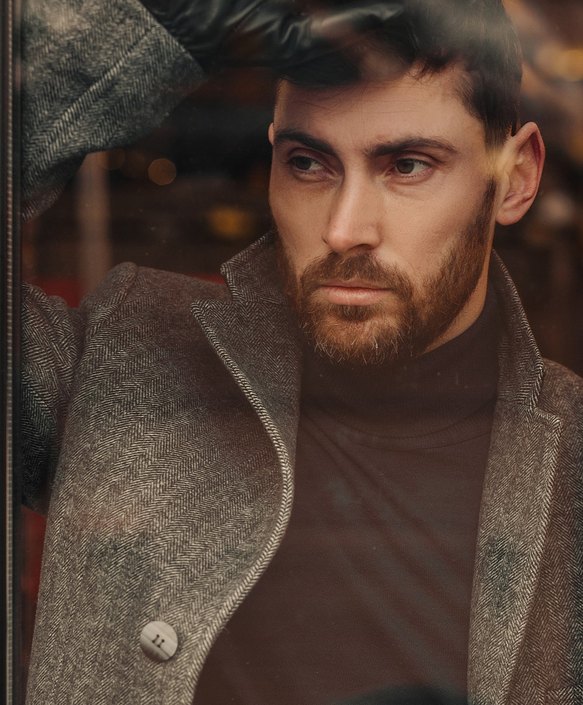 Man gazing thoughtfully through a window.