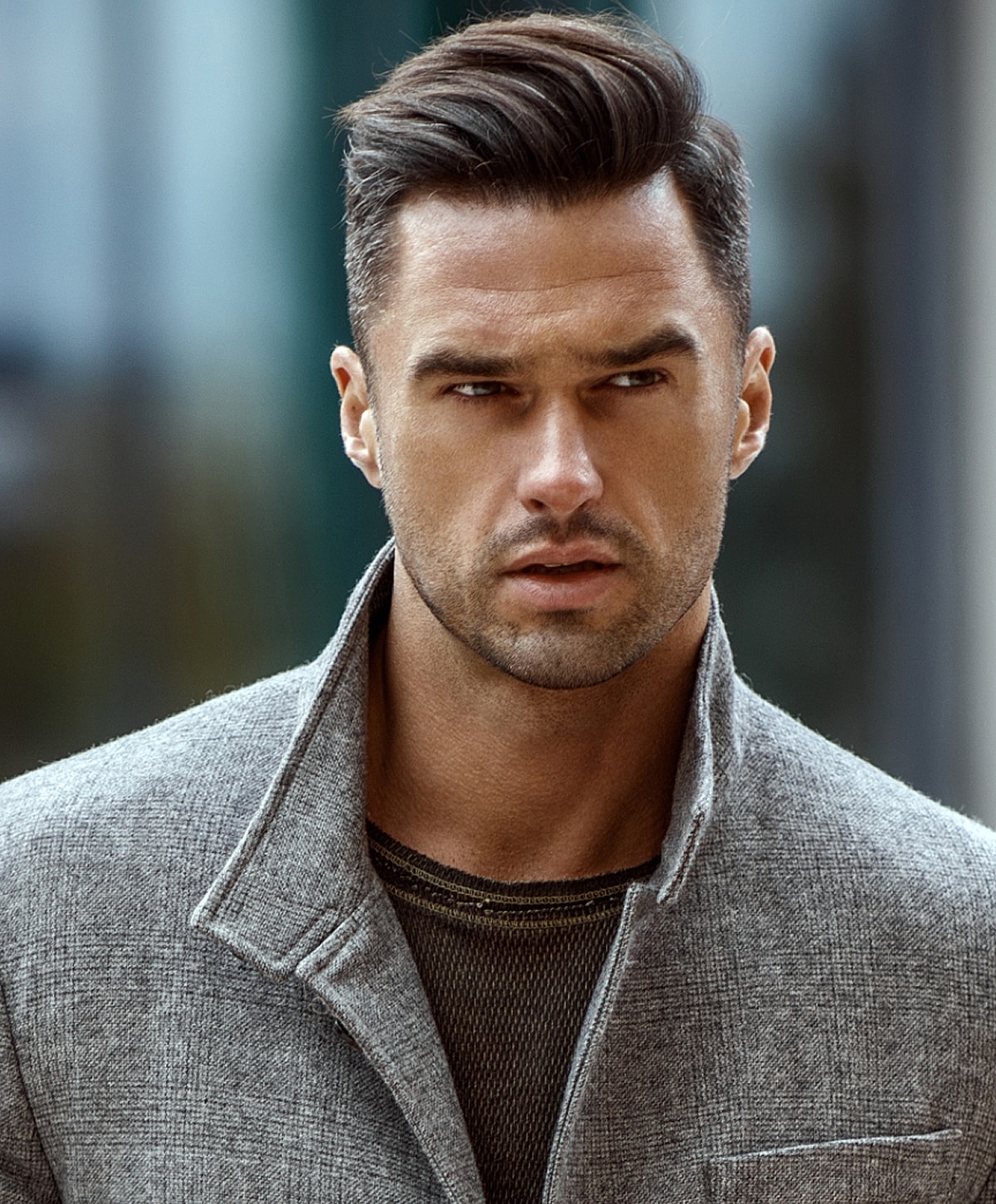 Man in stylish coat with intense expression.