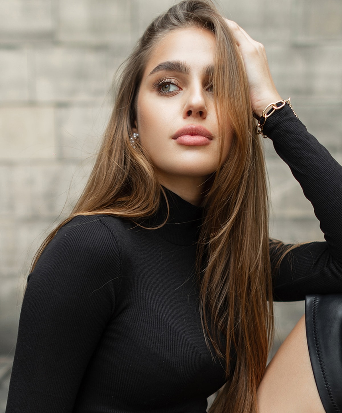 Woman in black sweater with long, flowing hair.